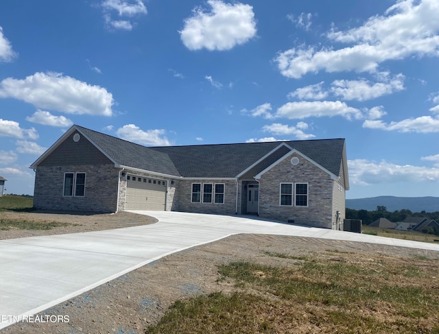 view of front of property featuring a mountain view, a garage, and central air condition unit