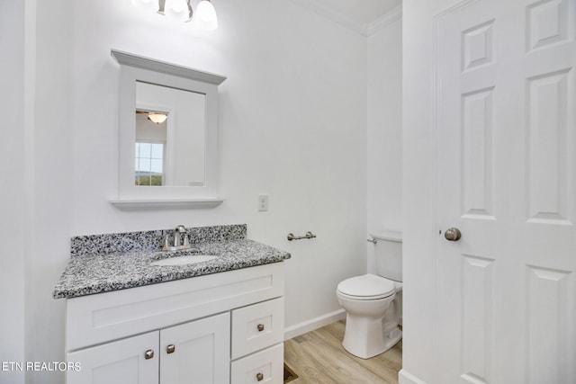 bathroom with vanity, hardwood / wood-style flooring, toilet, and crown molding