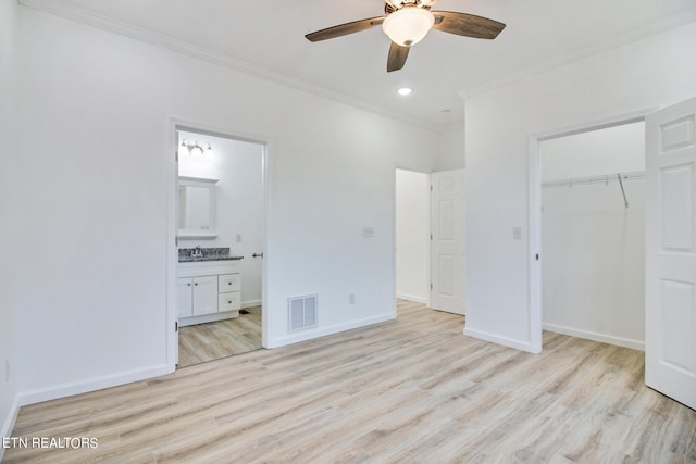 unfurnished bedroom featuring ensuite bathroom, light hardwood / wood-style flooring, ceiling fan, and crown molding