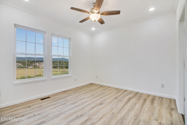 unfurnished room with a mountain view, light hardwood / wood-style flooring, ceiling fan, and crown molding