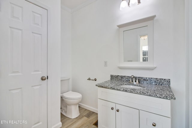 bathroom with vanity, hardwood / wood-style flooring, toilet, and ornamental molding