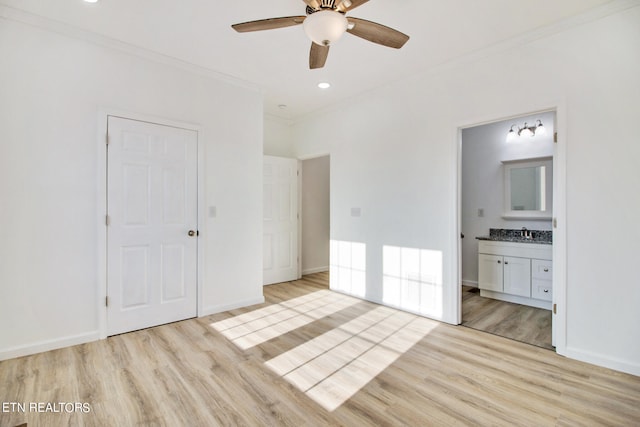 unfurnished bedroom featuring sink, light hardwood / wood-style flooring, ornamental molding, connected bathroom, and a closet