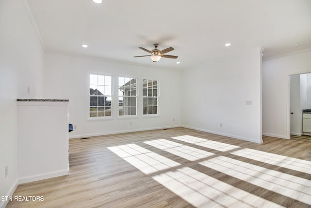 spare room with ceiling fan, light wood-type flooring, and crown molding