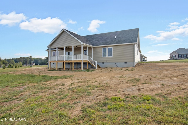 back of property featuring a yard and ceiling fan