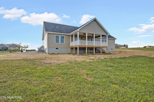 back of house with ceiling fan and a yard