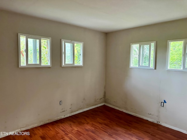 spare room with plenty of natural light and hardwood / wood-style floors