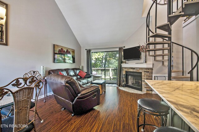 living room featuring lofted ceiling, dark hardwood / wood-style flooring, and a fireplace