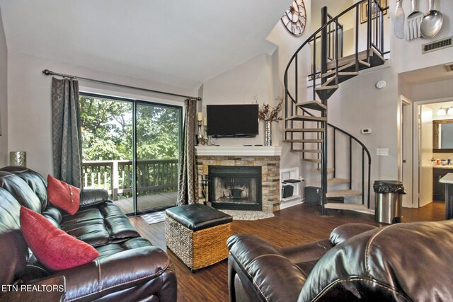 living room featuring a fireplace, vaulted ceiling, and wood-type flooring