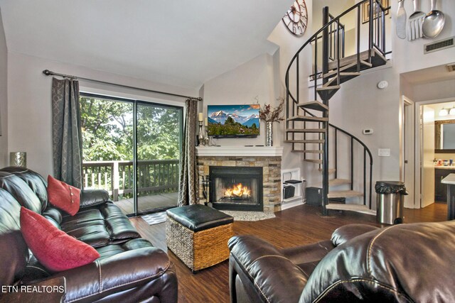 living room featuring vaulted ceiling, hardwood / wood-style flooring, and a fireplace