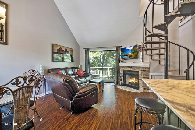 living room with a fireplace, lofted ceiling, and dark hardwood / wood-style floors