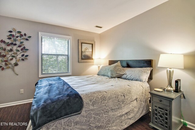 bedroom featuring dark wood-type flooring and vaulted ceiling