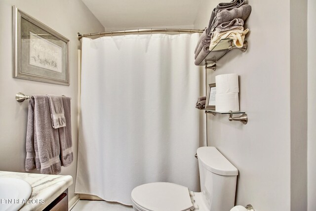 bathroom featuring a shower with shower curtain, toilet, and vanity