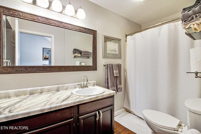 bathroom with vanity, toilet, a shower with shower curtain, and hardwood / wood-style flooring