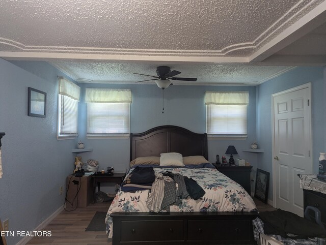 bedroom with ceiling fan, a textured ceiling, and hardwood / wood-style floors