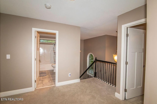 hall featuring baseboards, carpet flooring, and an upstairs landing