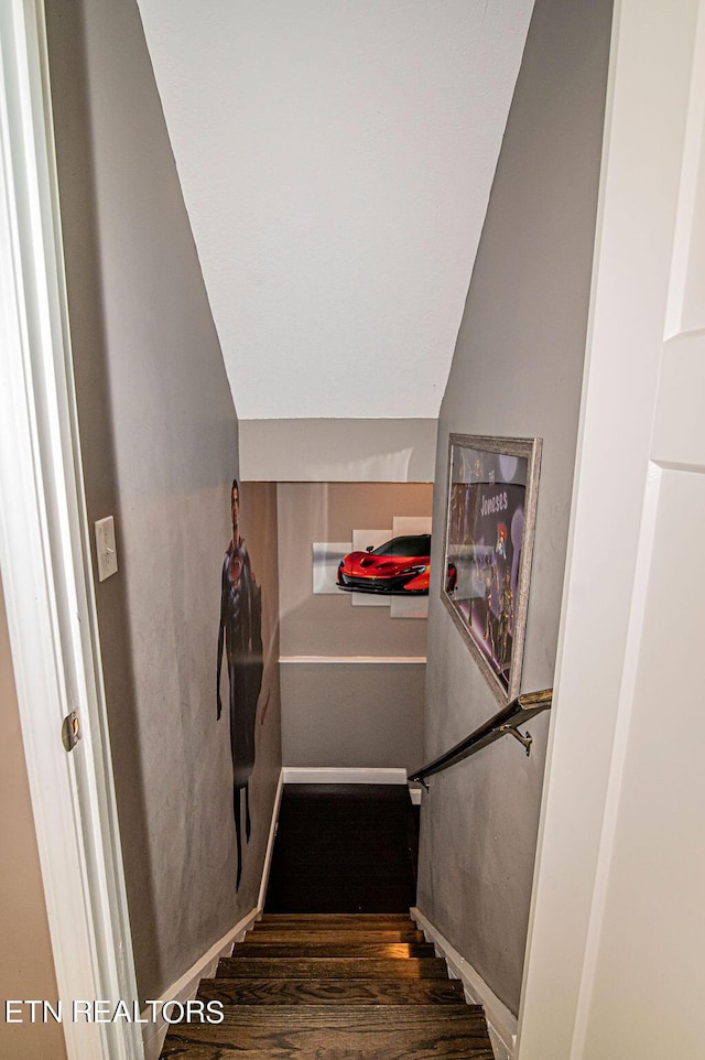 stairs with vaulted ceiling, baseboards, and wood finished floors