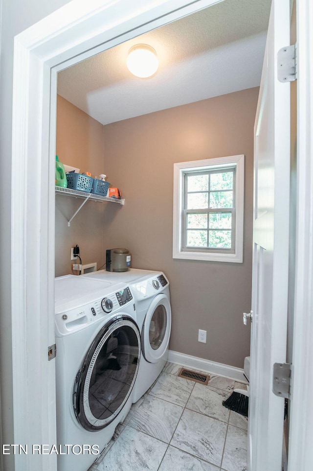 washroom featuring marble finish floor, washing machine and clothes dryer, visible vents, laundry area, and baseboards