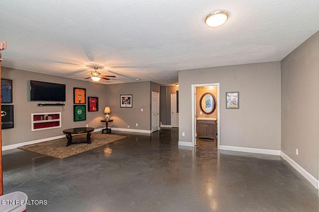 unfurnished living room with concrete flooring, a textured ceiling, a ceiling fan, and baseboards