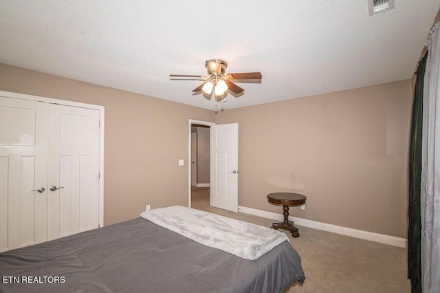 carpeted bedroom with baseboards, visible vents, ceiling fan, and a closet