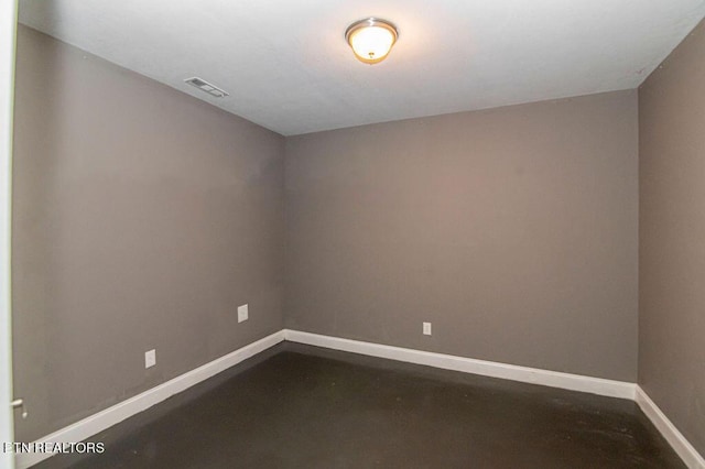 empty room featuring visible vents, baseboards, and concrete flooring