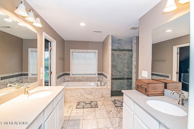 bathroom with a stall shower, visible vents, and a sink