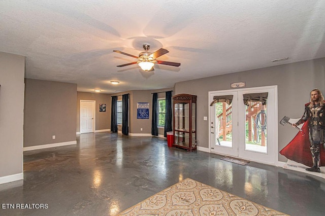 foyer entrance with finished concrete flooring, a textured ceiling, visible vents, and baseboards