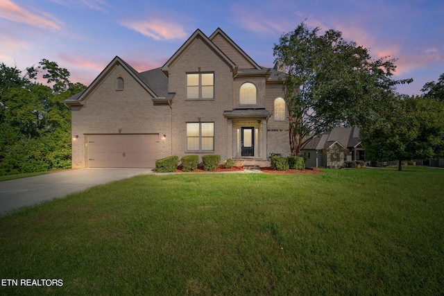 view of front of property featuring driveway, a garage, a front lawn, and brick siding