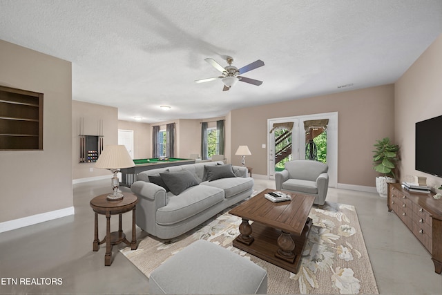 living area featuring finished concrete floors, billiards, a textured ceiling, and baseboards