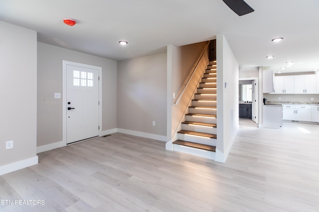 foyer entrance with light wood-type flooring and a healthy amount of sunlight