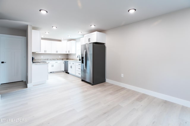 kitchen with white cabinets, sink, light hardwood / wood-style floors, and stainless steel appliances