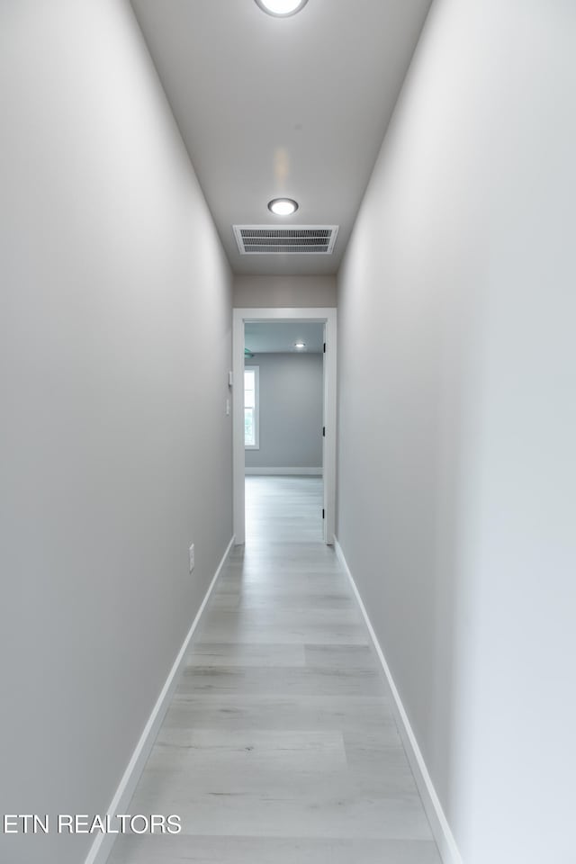 hallway with light hardwood / wood-style flooring