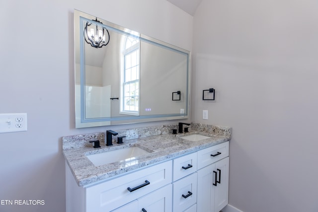 bathroom with a notable chandelier and vanity