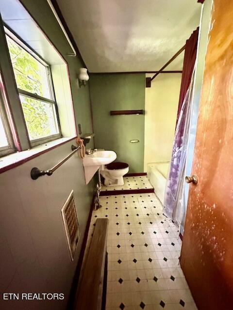 full bathroom featuring shower / tub combo, sink, toilet, and tile patterned flooring