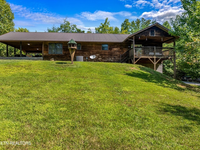 rear view of house featuring a lawn, a carport, and a deck