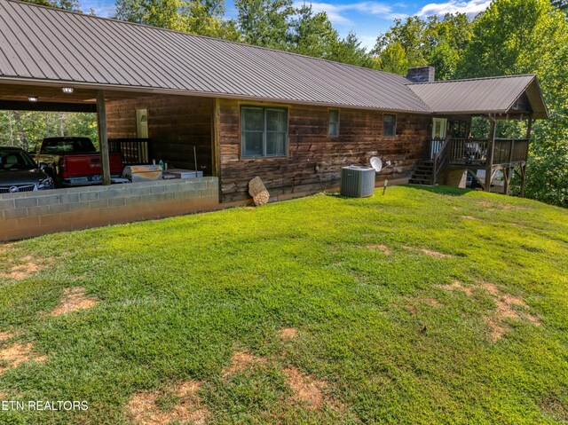 rear view of property with a yard and a carport