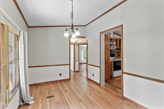 unfurnished dining area featuring light hardwood / wood-style floors, crown molding, and a notable chandelier