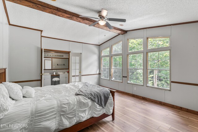 bedroom featuring vaulted ceiling with beams, ceiling fan, a textured ceiling, and light wood-type flooring