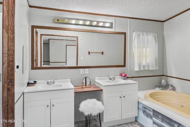 bathroom featuring vanity, a textured ceiling, and a tub