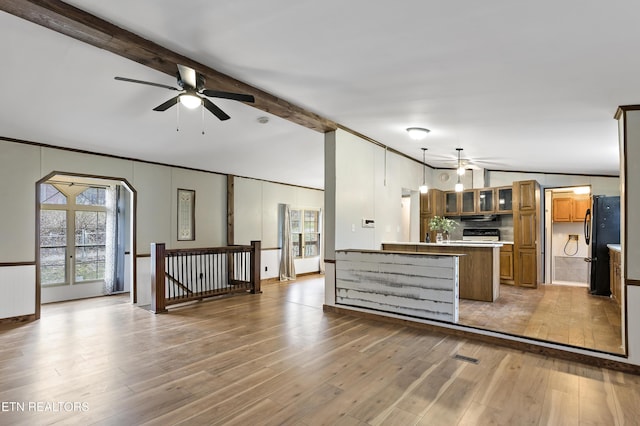 kitchen featuring black refrigerator, ceiling fan, lofted ceiling with beams, light hardwood / wood-style flooring, and hanging light fixtures