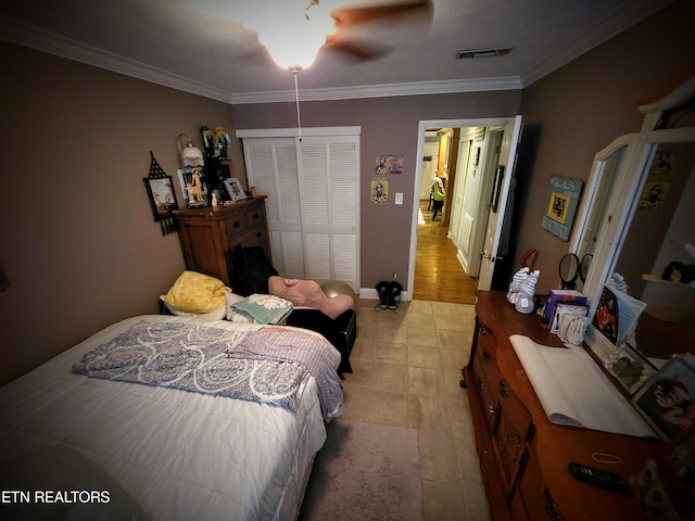 bedroom with light hardwood / wood-style flooring, ceiling fan, ornamental molding, and a closet