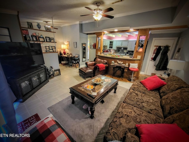 tiled living room with ceiling fan, crown molding, and a textured ceiling