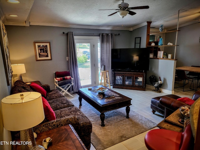 living room featuring ceiling fan, light tile patterned floors, ornamental molding, and a textured ceiling