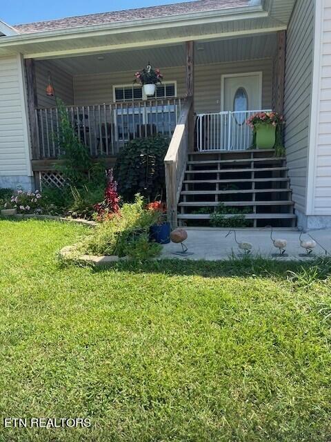 property entrance with a lawn and a porch