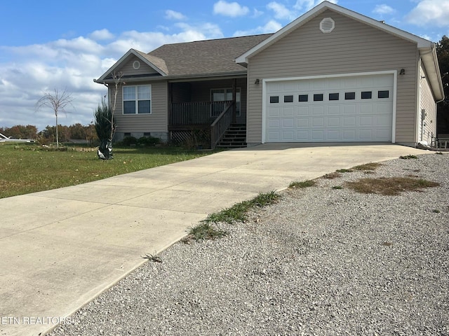 view of front of property with covered porch, a garage, and a front lawn