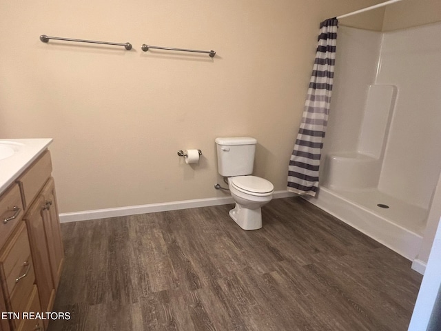 bathroom featuring vanity, a shower with shower curtain, hardwood / wood-style flooring, and toilet