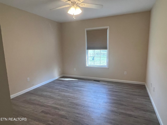 spare room featuring dark wood-type flooring and ceiling fan