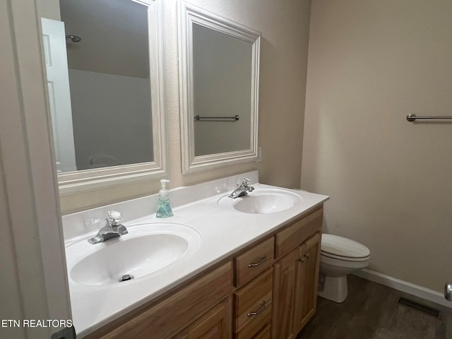 bathroom with vanity, toilet, and wood-type flooring