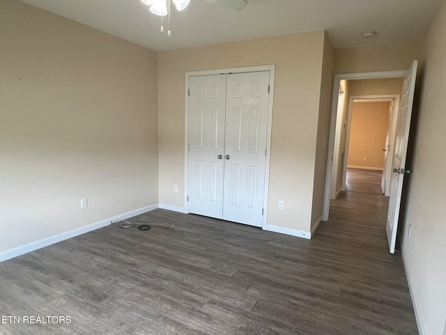 unfurnished bedroom with a closet, dark hardwood / wood-style floors, and ceiling fan