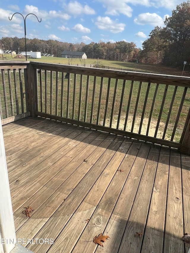 wooden deck featuring a lawn