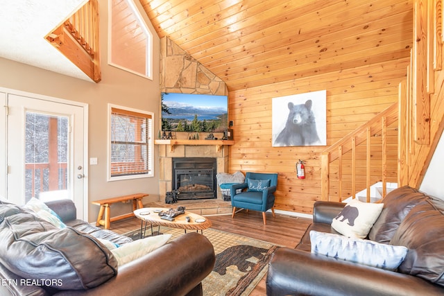 living room featuring hardwood / wood-style floors, wood walls, a fireplace, wood ceiling, and lofted ceiling